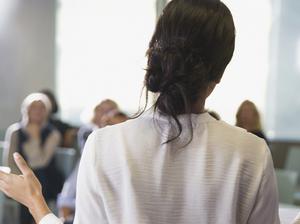 Businesswoman gesturing, leading conference room meeting