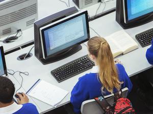 Elevated view of students sitting and learning in computer room