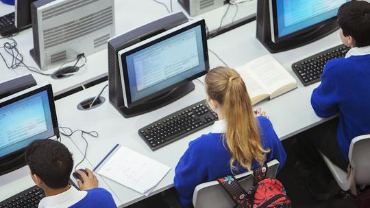 Elevated view of students sitting and learning in computer room