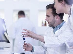 Laboratory workers looking at computer screen