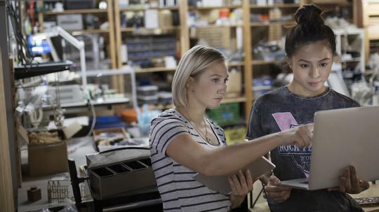 Female engineers using laptop in workshop