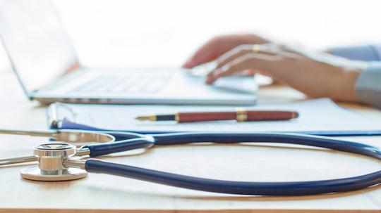 Doctor working on laptop and medical stethoscope on desk,Medical, Health Technology.Concept