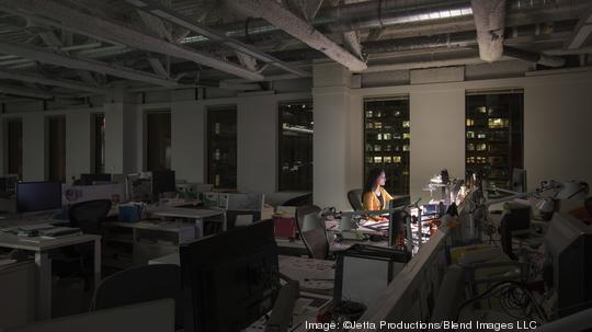 Mixed race businesswoman working late in office