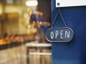 Close up of open sign on glass door to a bakery.