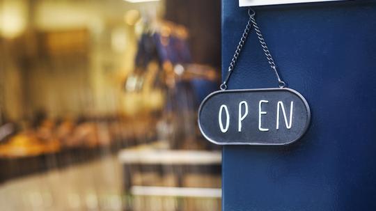 Close up of open sign on glass door to a bakery.