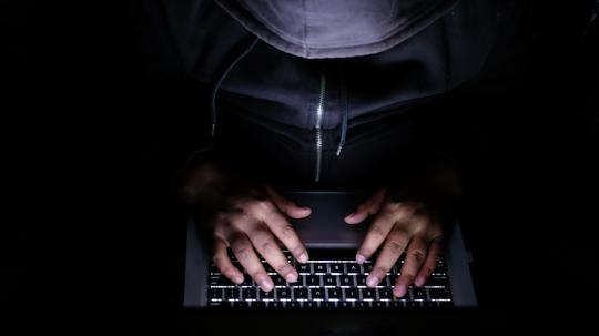 hacker Man with laptop stealing perdonal data from internet