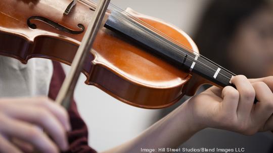 Caucasian student musician playing violin