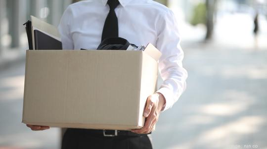 Close-up Of Unemployed Businessperson Carrying Cardboard Box