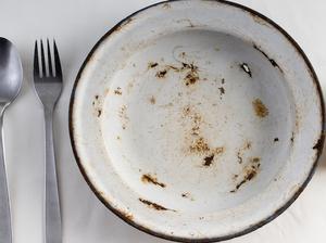 Table prepared with tablecloth, cutlery and metallic plate with a lata of empty conserve