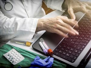 hands of doctor writing fast on laptop, conceptual image