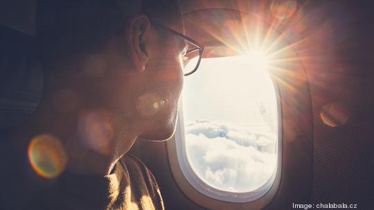 Man Looking Through Airplane Window During Sunny Day