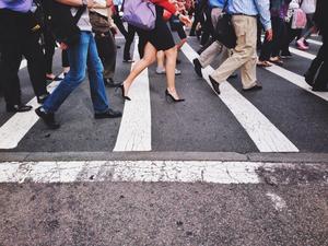 Low Section Of People Walking On Pedestrian Crossing On Street In City