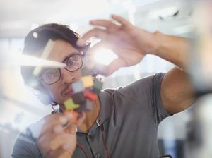 Focused, innovative male entrepreneur examining prototype