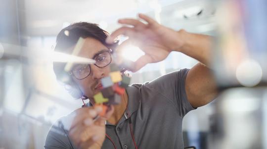 Focused, innovative male entrepreneur examining prototype