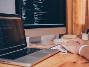 Cropped Image Of Computer Programmer Tying On Keyboard At Desk In Office