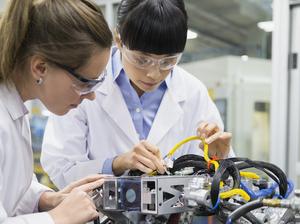 Engineers assembling robotics in factory