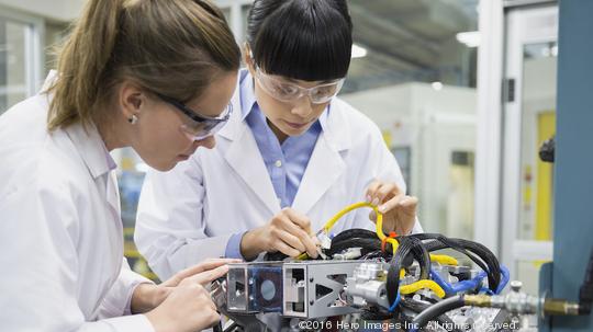 Engineers assembling robotics in factory