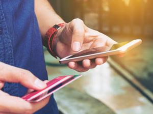 Midsection Of Man With Credit Card Using Smart Phone On Footpath