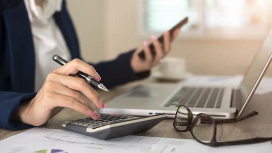 Close up of female accountant or banker making calculations. Savings, finances and economy concept