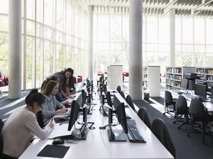 Students researching at computers in library