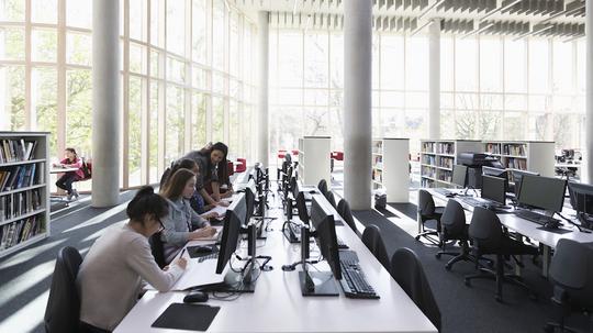 Students researching at computers in library