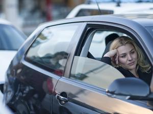 Bored businesswoman driving in city traffic jam