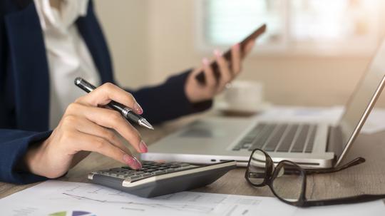 Close up of female accountant or banker making calculations. Savings, finances and economy concept