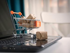 Close-Up Of Small Shopping Cart On Laptop