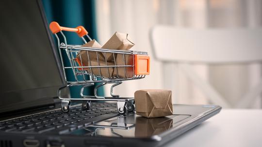 Close-Up Of Small Shopping Cart On Laptop