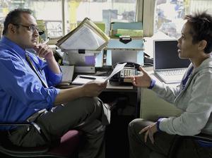 Manager talking to worker in factory office