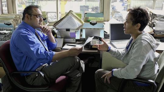 Manager talking to worker in factory office