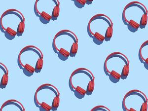 Collection of red wireless headphones on light blue background, 3D Rendering