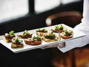 Waitress holding platter of organic appetizers