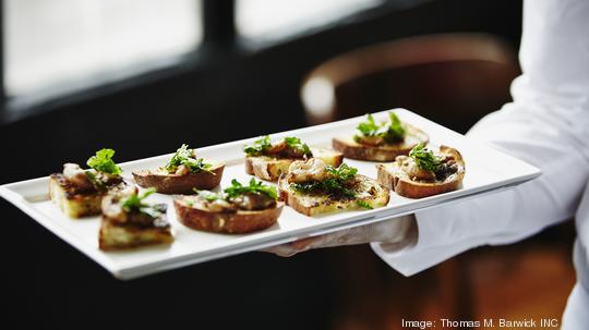 Waitress holding platter of organic appetizers