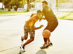 Basketball player dribbling ball past defender