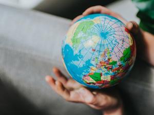 Childs hand holding a Globe