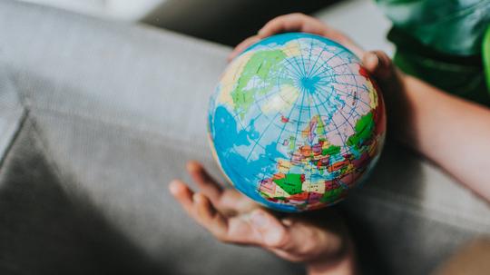 Childs hand holding a Globe