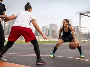 Basketball players playing in court against city