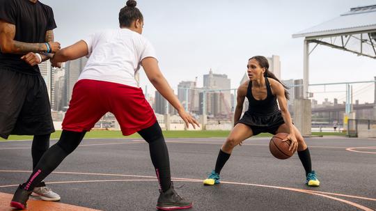 Basketball players playing in court against city