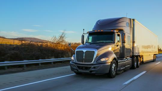 18 wheeler semi truck on road at sunrise