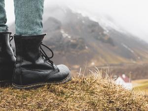 Iceland, legs of woman standing on hill