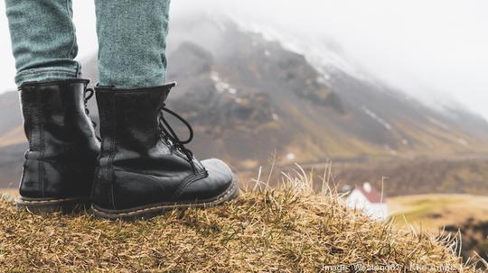 Iceland, legs of woman standing on hill