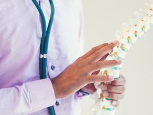 Man holding spine structure in his hand and demonstrating to patient.