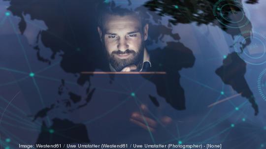 Businessman with tablet in car at night surrounded by data