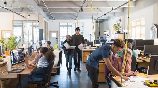 Creative business people working in open plan office