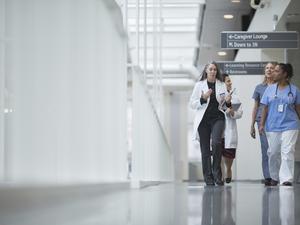 Female doctors discussing while walking in hospital corridor