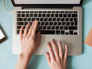 High view of caucasian woman using laptop at table