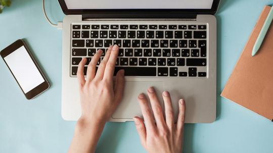 High view of caucasian woman using laptop at table