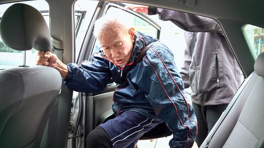 98-year-old senior male getting into a car.