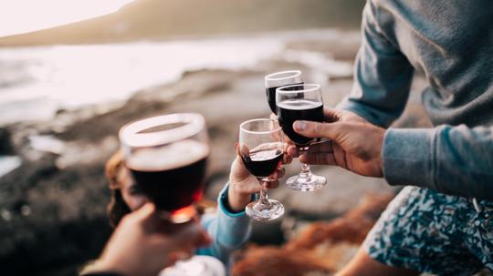 Midsection Of Friends Toasting Wineglasses